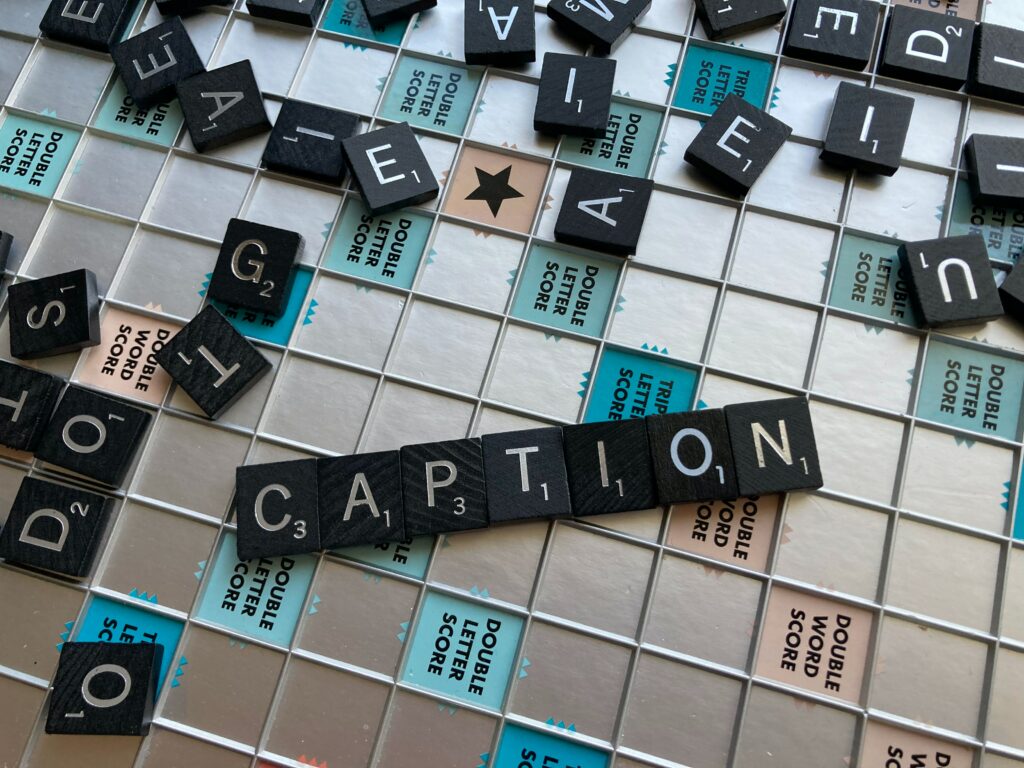 An image of tiles scattered across a scrabble board.  There are tiles in the centre of the image, that are arranged to spell the word "CAPTION."
