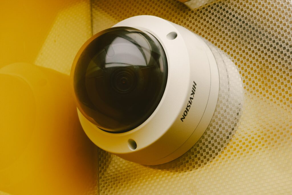 A close-up photograph of a security camera mounted on a shiny golden wall.